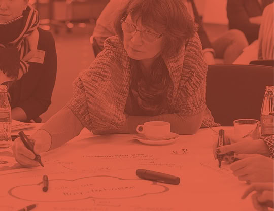 Eine Teilnehmende eines Workshops macht Notizen