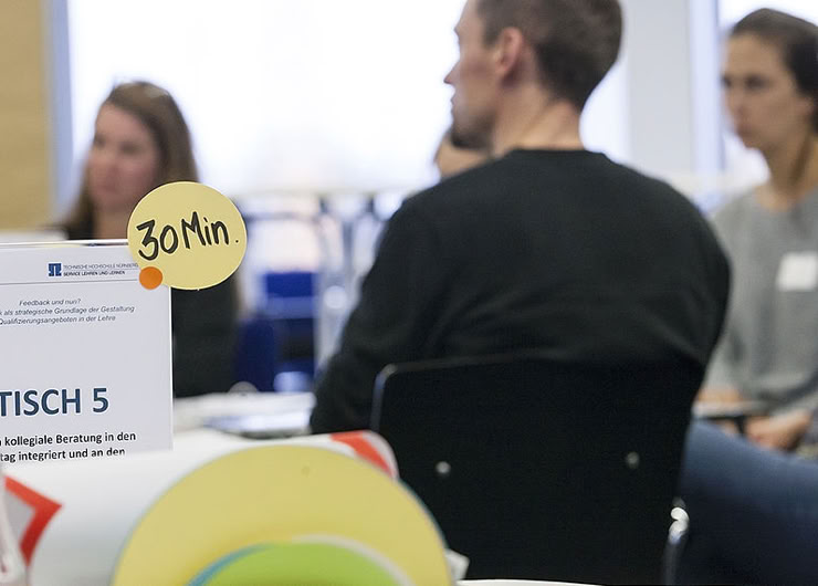 Personen an einem Worldcafé-Tisch